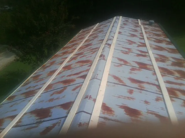 Rusted metal roof panels with new wood purlins before replacement — Storm Damage Roof Repair in Springtown by Roofing Brothers