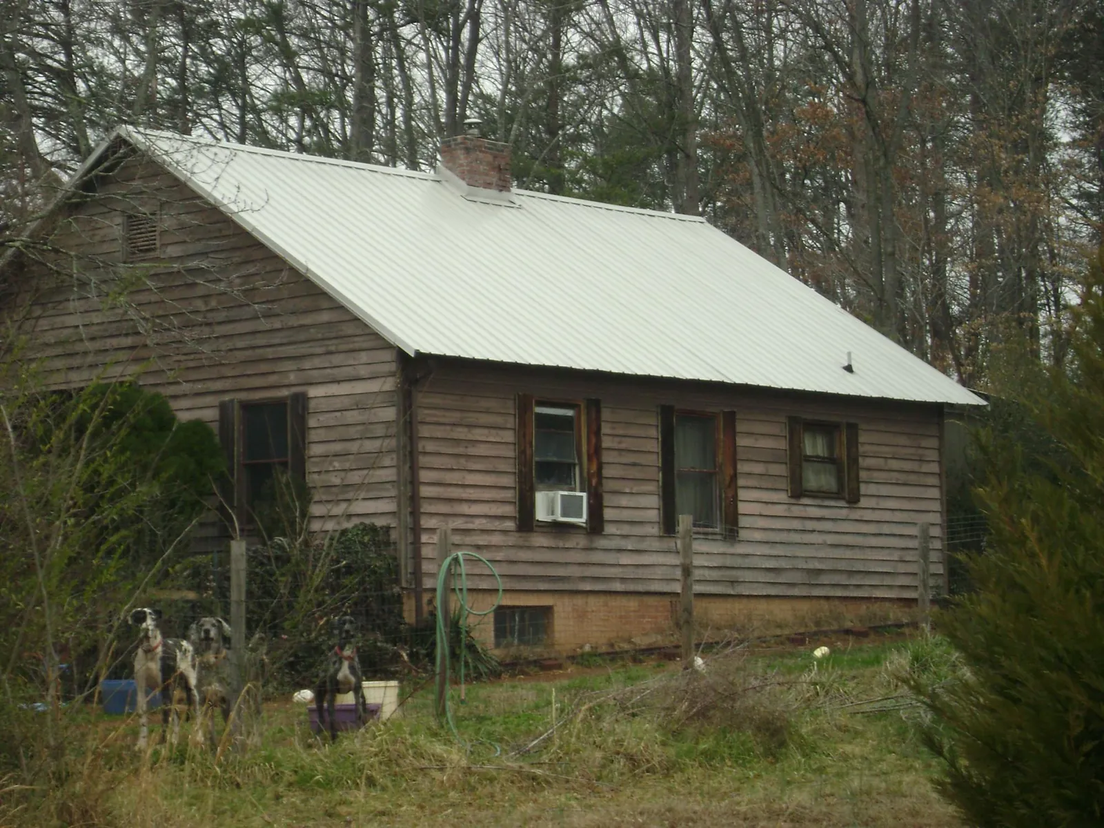 White metal roof on an old wood sided farmhouse, from a Metal Roof Installation job in Springtown